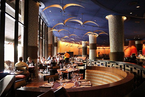 inside a restaurant dining room with a blue ceiling and lights that look like flying birds