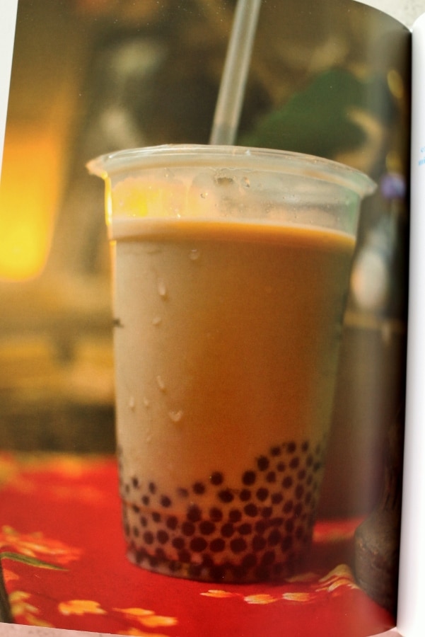 A clear plastic cup of bubble tea with a straw