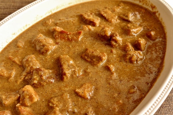 a closeup of a serving dish of pork vindaloo curry