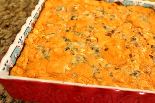 a closeup of buffalo chicken dip in a red square baking dish