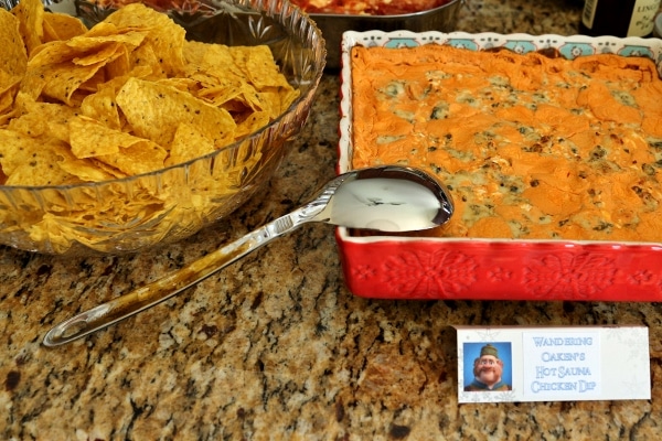 a bowl of tortilla chips and a square baking dish of buffalo chicken dip