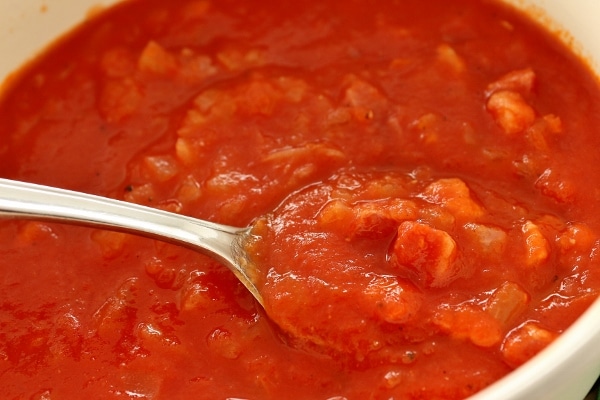A closeup of Amatriciana sauce with tomato puree, pancetta and onions in it