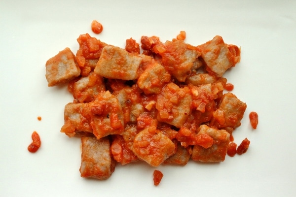 overhead view of gnocchi pasta with Amatriciana sauce on a white plate