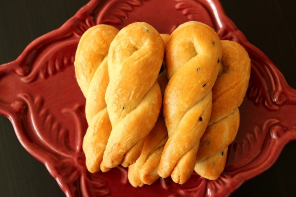 Simit twists piled high on a square maroon plate