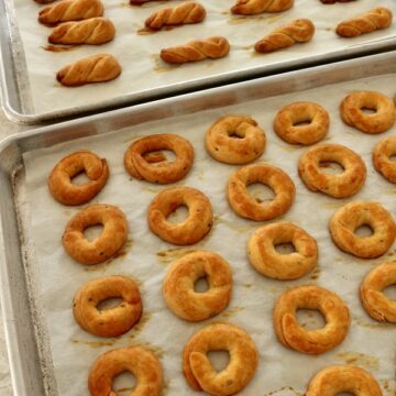 Two trays of baked Armenian khalkha (simit), half shaped into rings, the other into twists