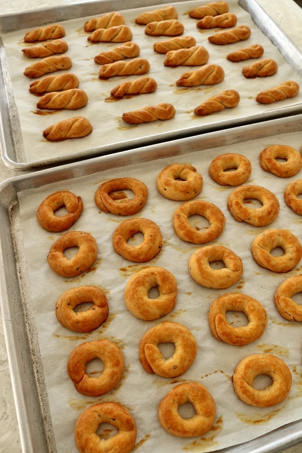 Two trays of baked Armenian khalkha (simit), half shaped into rings, the other into twists