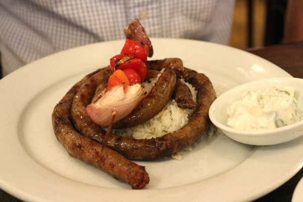 a long piece of merguez sausage served over rice on a plate