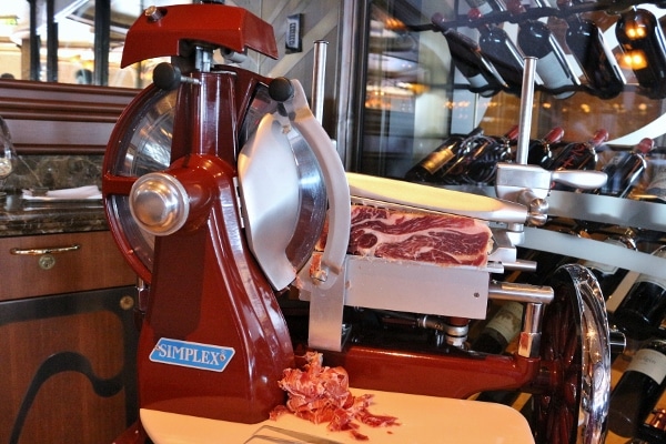 a meat slicer on a table cutting Spanish style ham