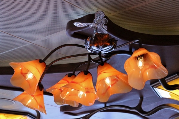 a glass Ratatouille figurine on top of an orange lighting fixture