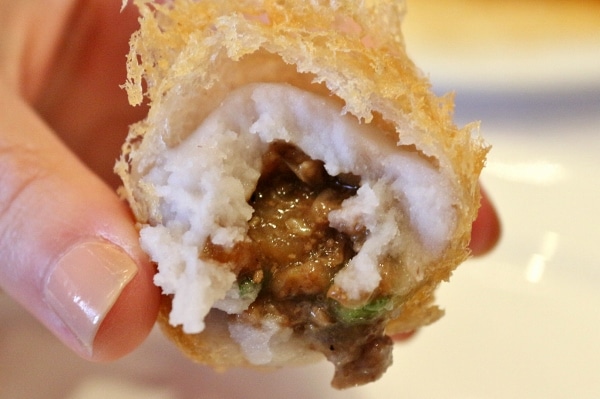 a closeup of a half eaten taro dumpling with juicy meat filling