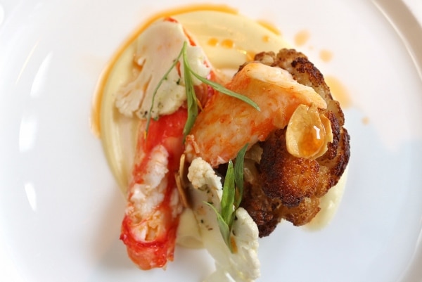 overhead view of an artful plate of food featuring crab meat and cauliflower