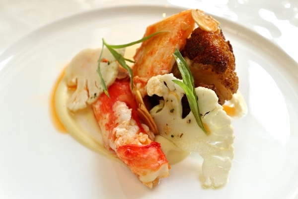 side view of an artful plate of food featuring crab meat and cauliflower