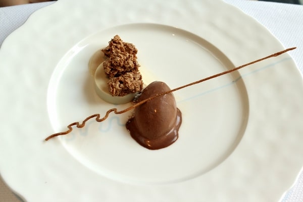 an artful looking chocolate dessert on a big white plate