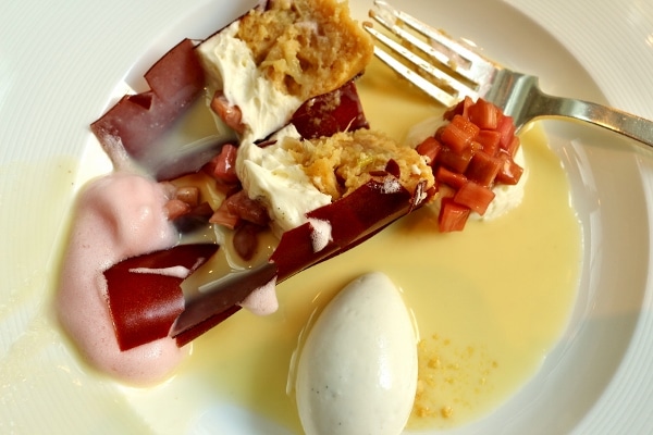 a plate of food with ice cream, rhubarb compote, and bread pudding