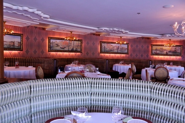 a restaurant dining room with photos of Venice on the wall