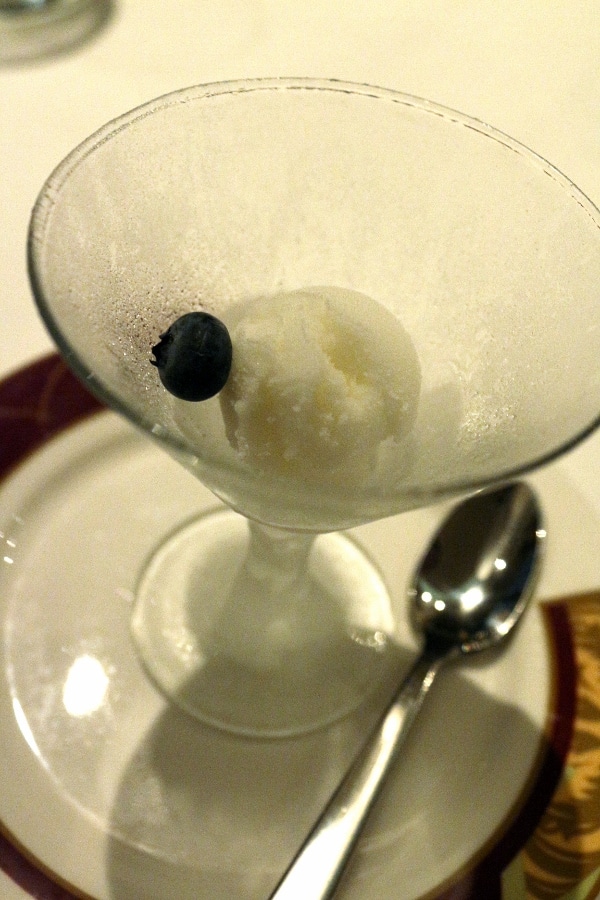 a tiny scoop of sorbet with a blueberry in a small cocktail glass