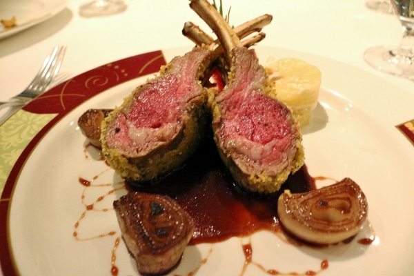 A plate of rare lamb chops with roasted onions