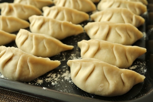 A tray of uncooked homemade dumplings