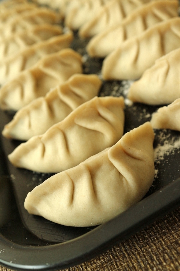 A tray of uncooked homemade dumplings