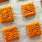 overhead closeup of homemade cheddar cheese crackers on a baking sheet
