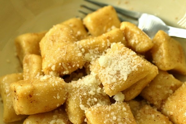 A closeup of dunderi gnocchi in a shallow bowl topped with cheese