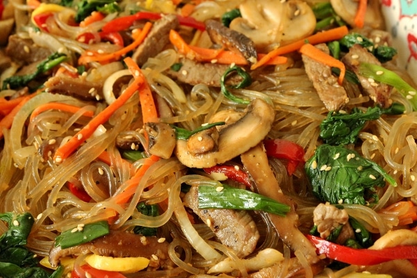 a closeup of sweet potato noodles with colorful vegetables