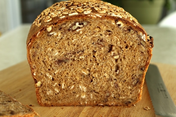 a cross-section of a loaf of whole wheat sandwich bread with oats and pecans