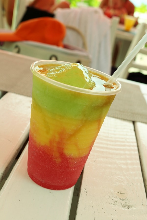 a frozen cocktail with red, orange, and green layers