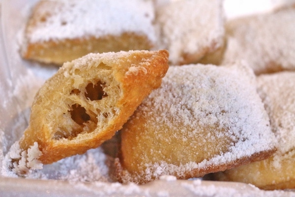 A close up of beignets topped with powdered sugar