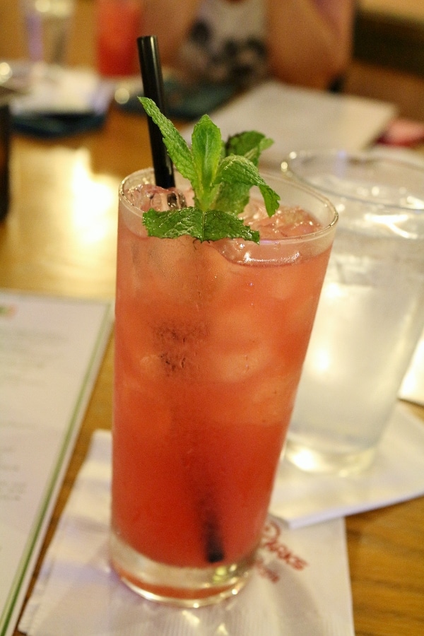 a drink in a tall glass garnished with fresh mint