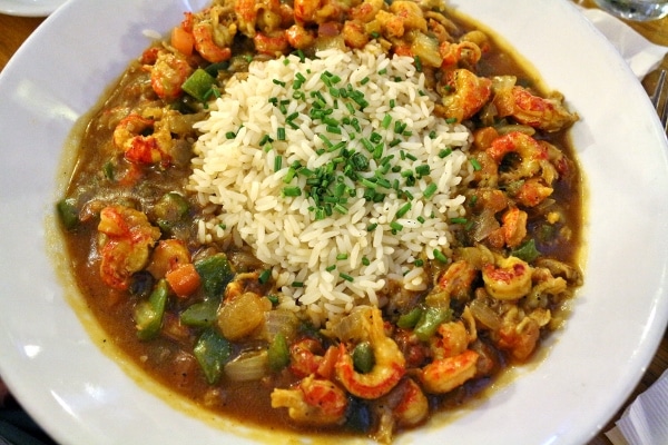 a bowl of crawfish etouffee with a pile of white rice in the center