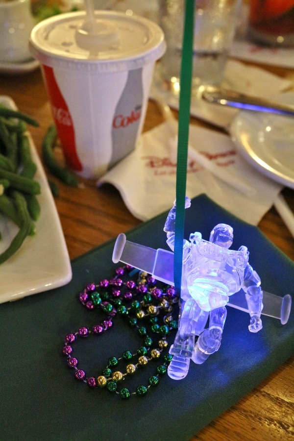 a light-up Buzz Lightyear and mardi gras beads on a table