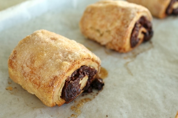 A closeup date and chocolate rugelach on a baking sheet