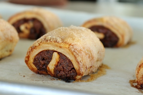 A closeup of date and chocolate rugelach on a baking sheet