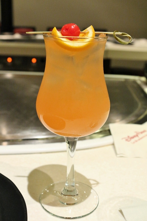 an orange colored cocktail in a glass