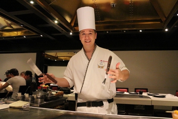 A hibachi chef doing tricks with his cooking utensils