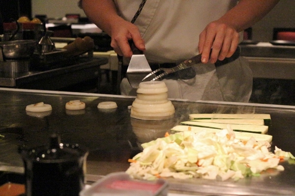 a chef\'s hands making a volcano out of onion slices