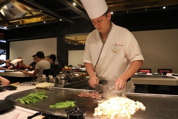 A chef in a hibachi restaurant preparing food