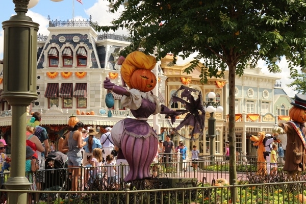 a jack-o-lantern statue dressed like a woman in a purple dress