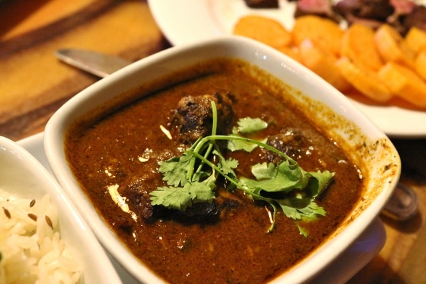 A bowl of lamb curry in a dark sauce