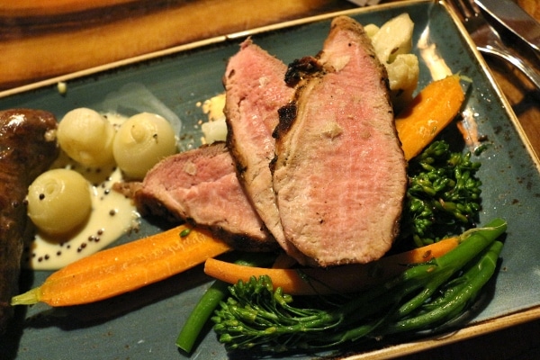 a closeup of sliced pork tenderloin served with vegetables