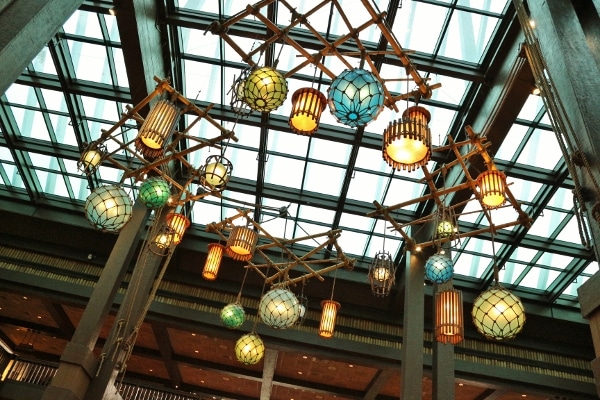 a view looking up at brightly colored hanging lights and glass skylights over the Polynesian lobby