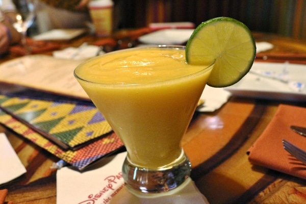 A frozen mango drink with a lime garnish