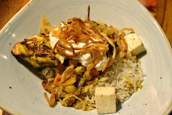 A plate biryani rice with chicken and vegetables
