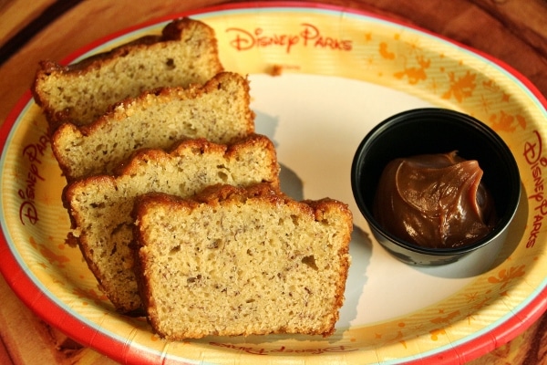 sliced banana bread on a plate with chocolate hazelnut spread on the side