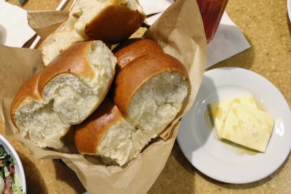 A basket of bread with butter on the side