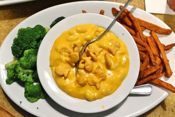 a plate of broccoli, sweet potato fries, and macaroni and cheese