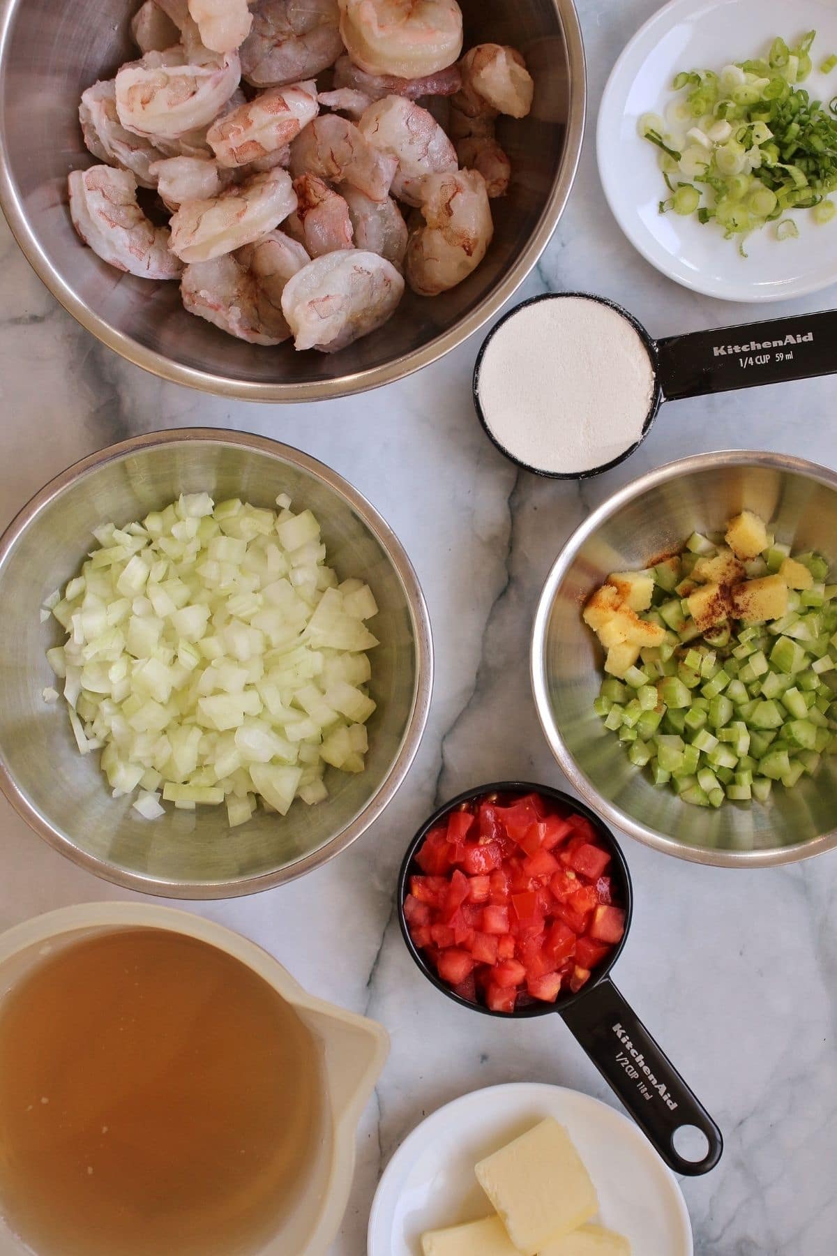 bowls and measuring cups filled with ingredients for shrimp etouffee