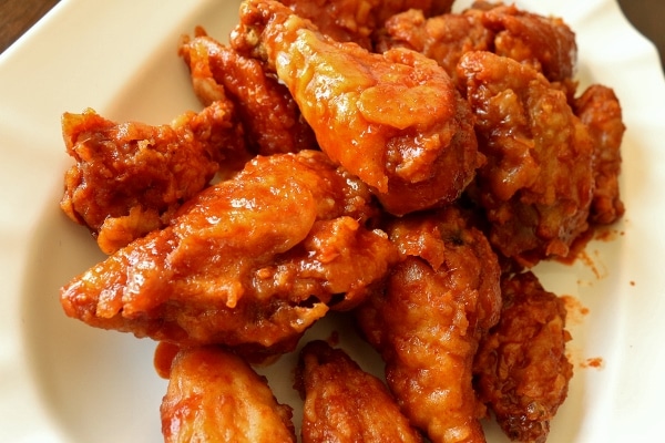 closeup of Korean fried chicken in spicy red sauce