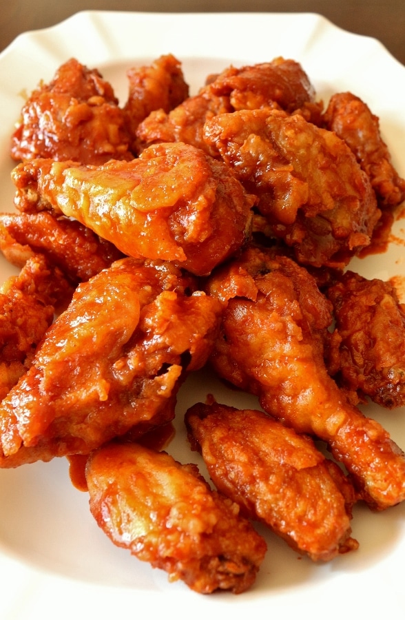 closeup of a platter of Korean fried chicken with a spicy red sauce